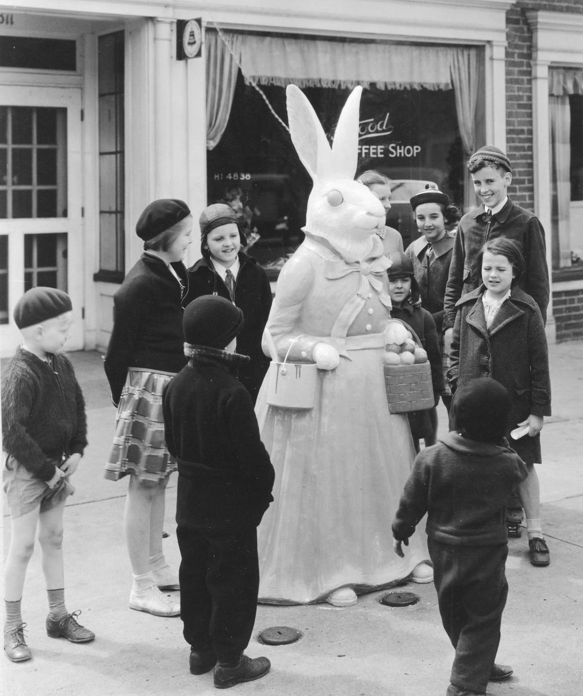 A group of children stands near an Easter bunny statue at Crestwood Shops in 1923. The bunnies were on display outside the Crestwood Shops for nine years before moving to their long-time home on Country Club Plaza.