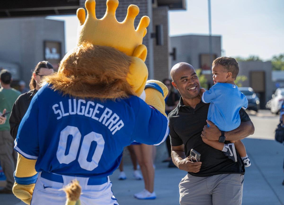 Royals mascot Sluggerrr greeted fans, including 18-month-old Cruz Ashton and his father, Preston Ashton of Kansas City, during the Bring Out the Blue tailgating event at the Price Chopper in Lee’s Summit on Monday, Sept. 30, 2024.
