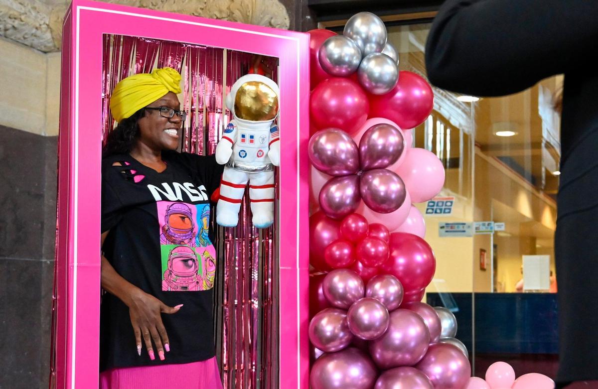 With a Mission Commander doll, Barbie fan Kenya Shobe of Kansas City, posed in a life-size Barbie box to have a photo taken Thursday at Union Station.