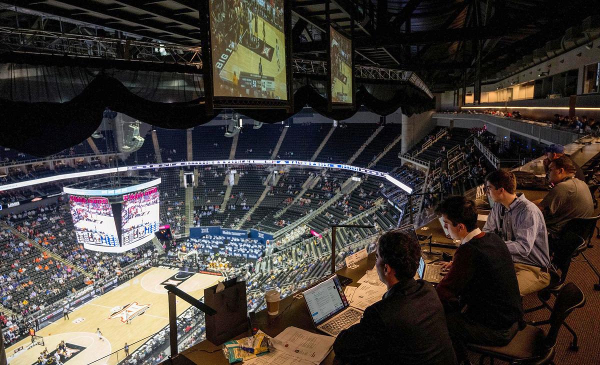 Up high near the ceiling of the T-Mobile Center, members of the media sit at press row and keep notes as Cincinnati plays West Virginia during the Big 12 basketball tournament on Tuesday.