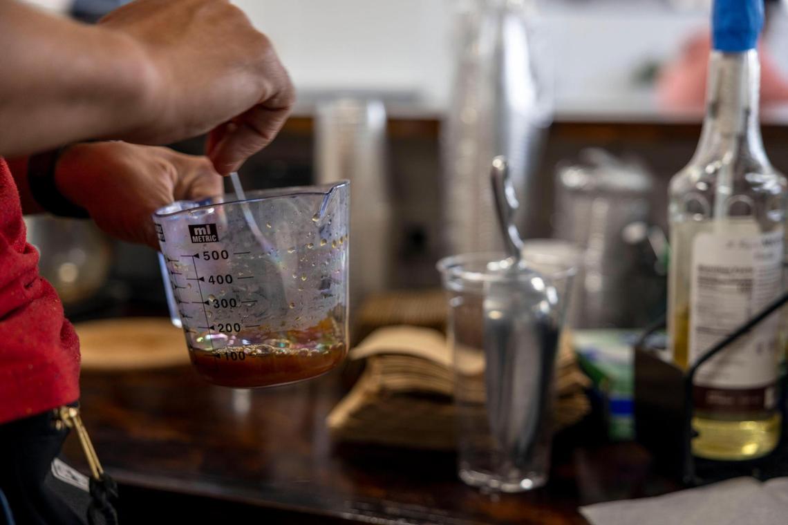 TJ Roberts, owner of Kinship Cafe, prepares a caramel cold brew coffee.