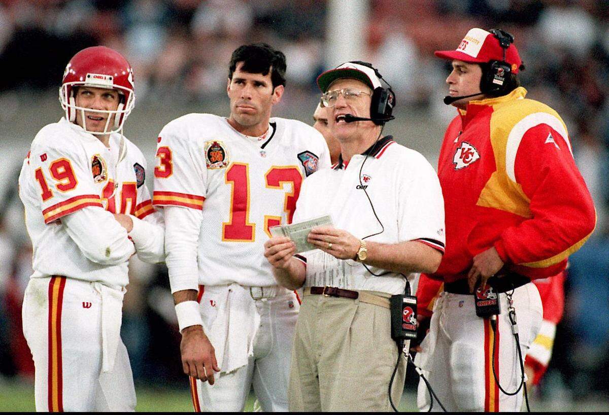 Kansas City Chiefs quarterbacks Joe Montana, from left, Steve Bono and Matt Blundin listen to head coach Marty Schottenheimer during a game in 1994. 