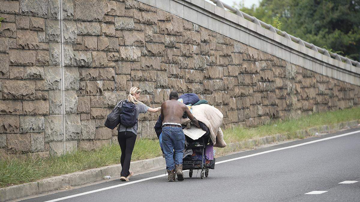 A homeless advocate helps a man who was displaced and removed from his tent relocate himself and belongings away from the Kennedy Center area in Washington, D.C. 