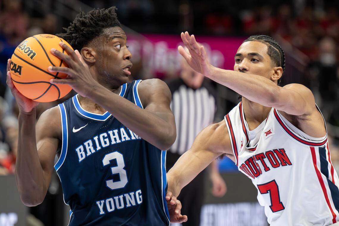 BYU Cougars forward AJ Dybantsa (3) shields the ball from Houston Cougars guard Milos Uzan (7) during the second half of a Big 12 Men's Basketball Tournament game at T-Mobile Center on Thursday, March 12, 2026, in Kansas City.