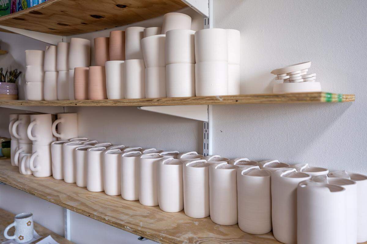 Unfinished ceramic mugs, bowls and cups made by ceramicist Priscilla Butler sit on shelves at her studio, Lila's Clayground, Thursday, Jan. 29, 2026, in Kansas City.