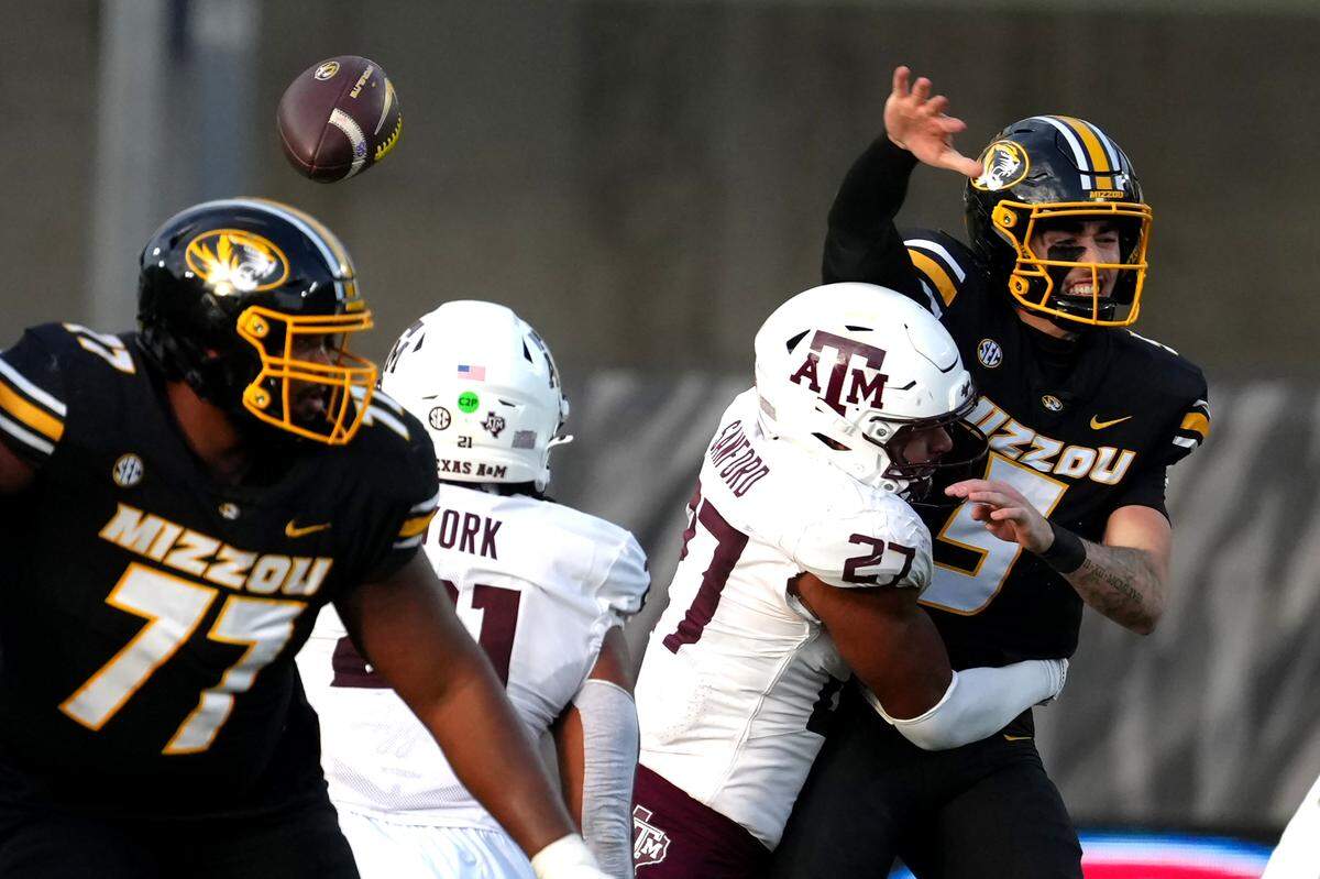 Quarterback Matt Zollers #5 of the Missouri Tigers loses the ball as he is hit by Daymion Sanford #27 of the Texas A&M Aggies in the first half at Faurot Field at Memorial Stadium on November 8, 2025 in Columbia.