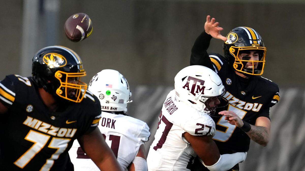 COLUMBIA, MISSOURI - NOVEMBER 08: Quarterback Matt Zollers #5 of the Missouri Tigers looses the ball as he is hit by Daymion Sanford #27 of the Texas A&M Aggies in the first half at Faurot Field at Memorial Stadium on November 08, 2025 in Columbia, Missouri. (Photo by Ed Zurga/Getty Images)