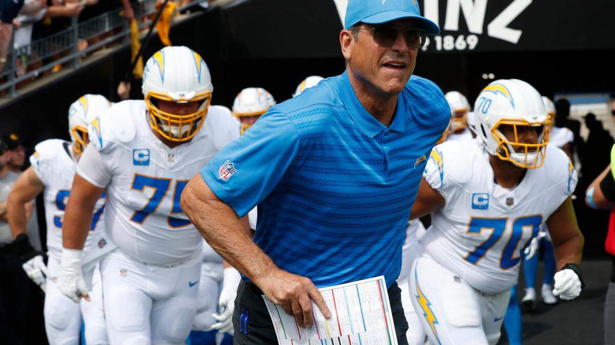 Los Angeles Chargers head coach Jim Harbaugh leads his team onto the field to play the Pittsburgh Steelers at Acrisure Stadium.