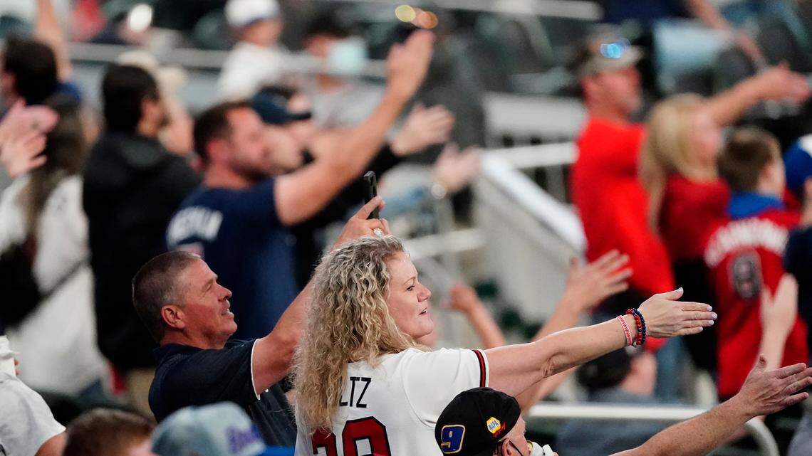 Atlanta Braves fans do the Tomahawk Chop during a baseball game against the Philadelphia Phillies Saturday, April 10, 2021, in Atlanta. (AP Photo/John Bazemore)