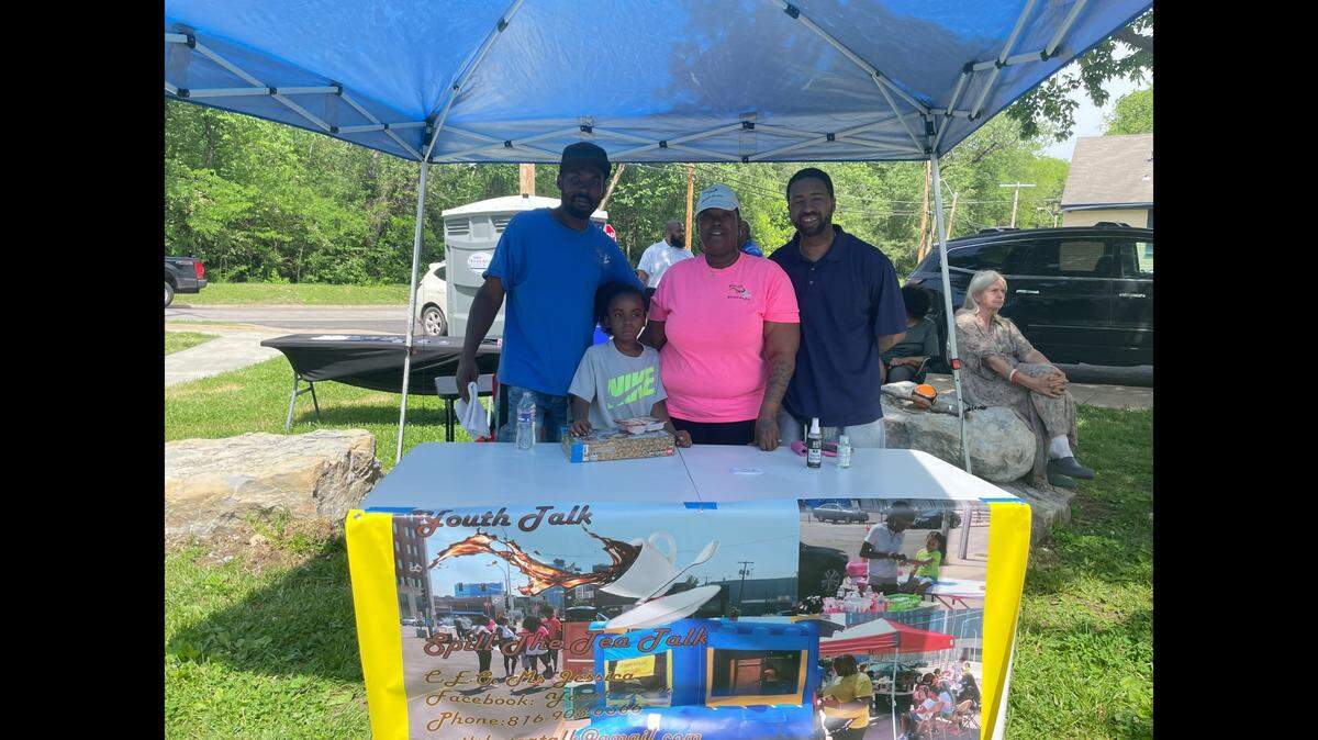 Antonio Caldwell, left, DeMarco Johnson, Jessica Johnson and Brandon Ellington sit behind a booth for the organization “Youth Talk,” which is connecting community members with mental health counseling.