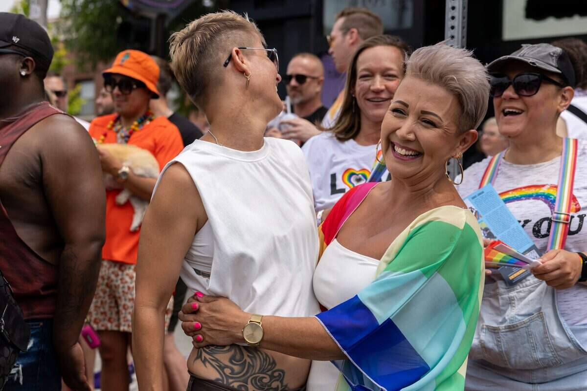 Stacey George, 43, left, and Jules Shelton, 52, hug one another as they watch Kansas City's Annual Pride Parade at Westport Rd on Saturday, June 6, 2026.