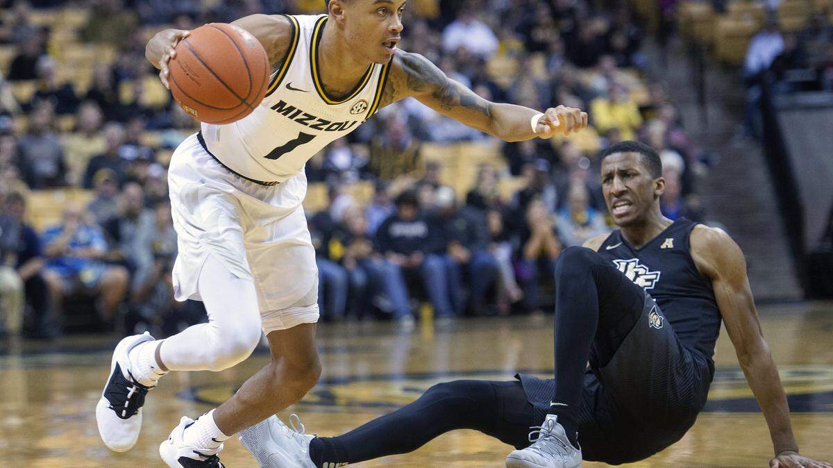 Missouri’s Xavier Pinson, left, dribbles past a falling Central Florida’s Aubrey Dawkins, right, during the first half of an NCAA college basketball game Sunday, Dec. 2, 2018, in Columbia, Mo. (AP Photo/L.G. Patterson)