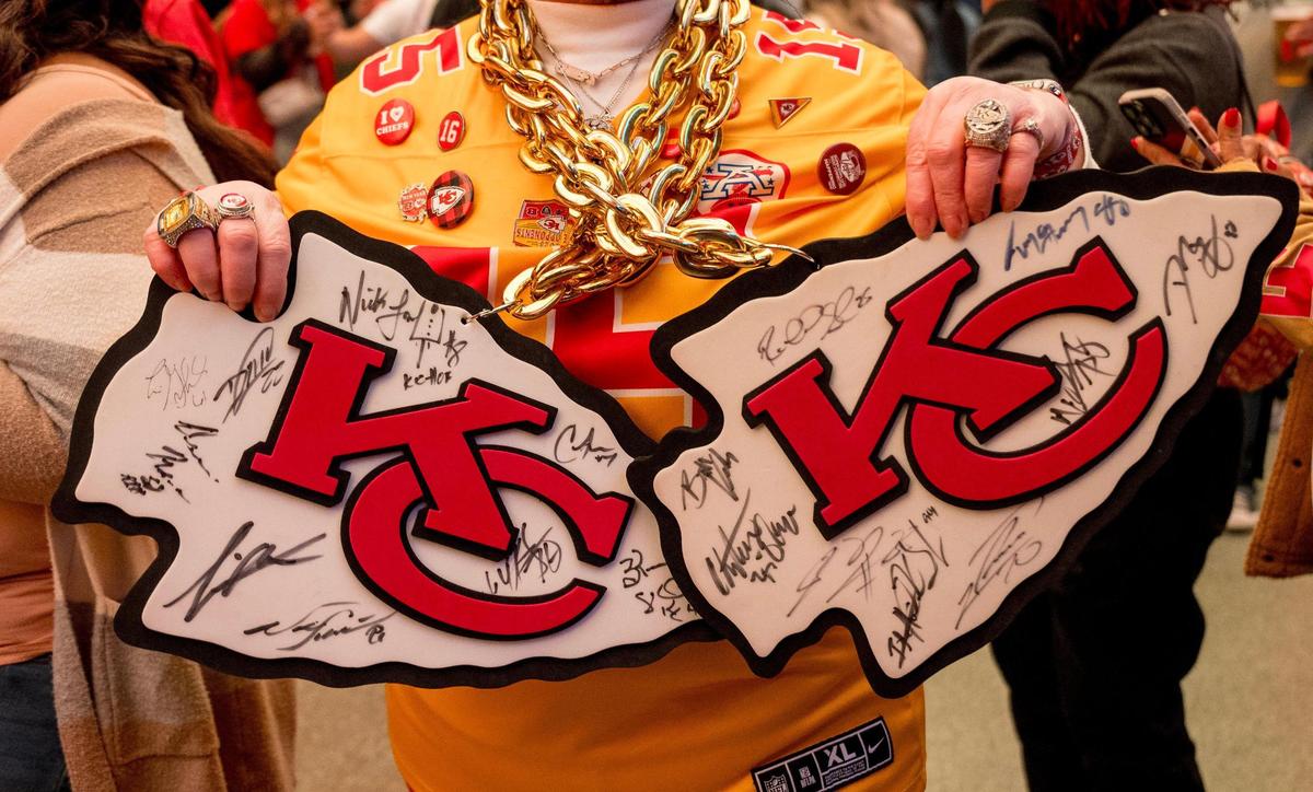 Tammy Allen of Las Vegas holds up autographed Chiefs logos during a fan gathering on Saturday, Feb. 10, 2024, in Las Vegas.