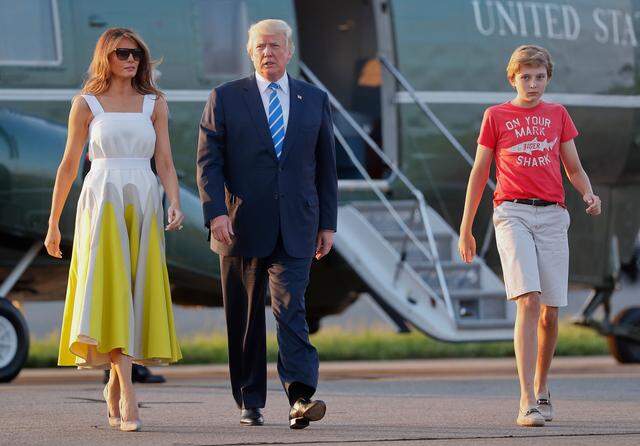 President Donald Trump, first lady Melania Trump and son Barron Trump walk across the tarmac to board Air Force One at Morristown Municipal Airport on Aug. 20, 2017, in Morristown, N.J.