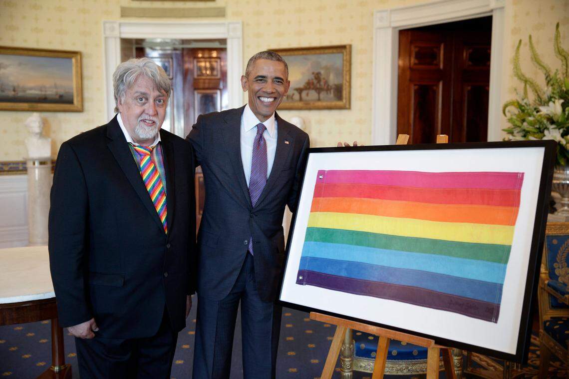 President Barack Obama views the original eight-color Gay Pride Flag with Kansas native Gilbert Baker, the artist who designed the flag, prior to a reception in recognition of LGBT Pride Month in the Blue Room of the White House on June 9, 2016.