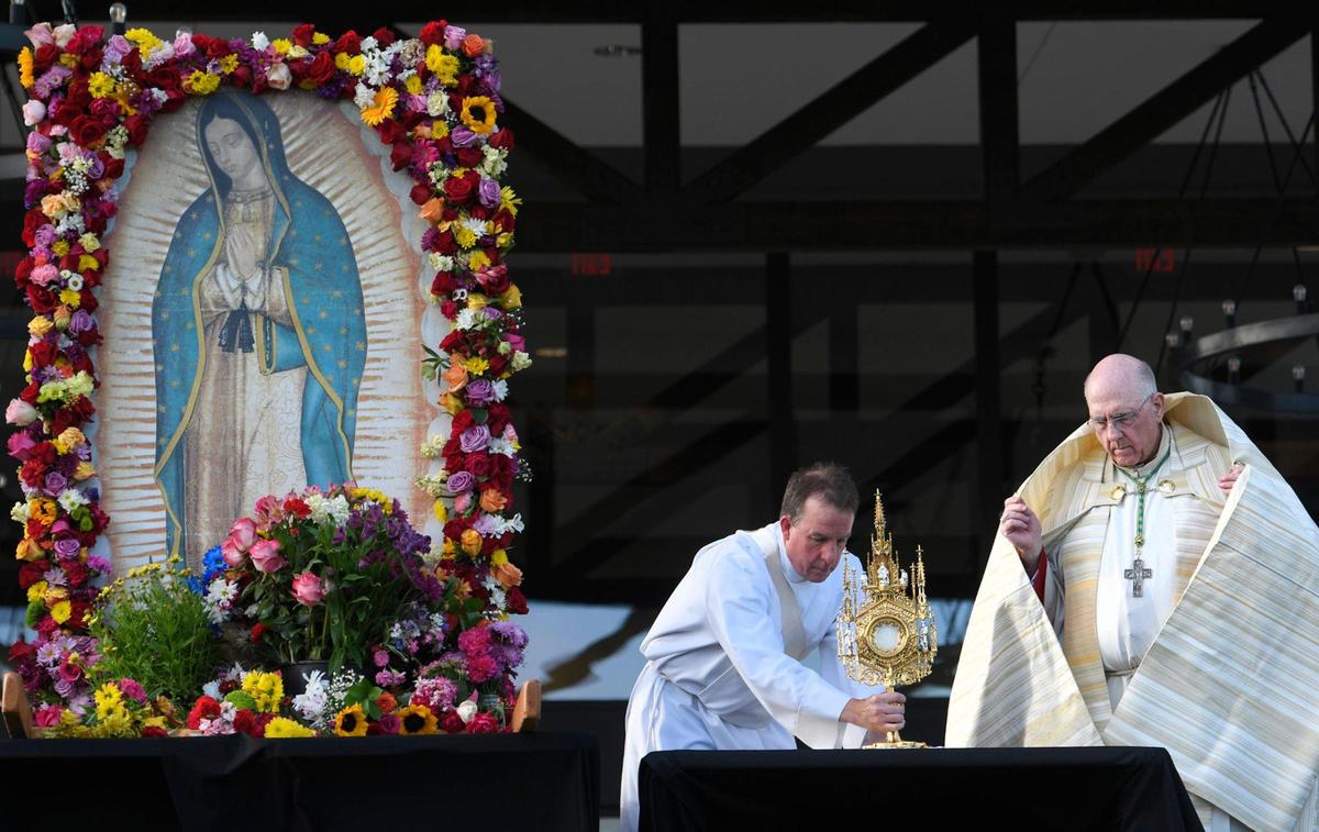 Deacon John Weist, left, of St. Michael the Archangel in Leawood, places the monstrance before Archbishop Joseph F. Naumann during the Value Them Both Tailgate and Rosary Rally held June 5 at Fiorella’s Event Center in Overland Park. A prayer and a rosary were led by the Archbishop in support of the Value Them Both constitutional amendment.