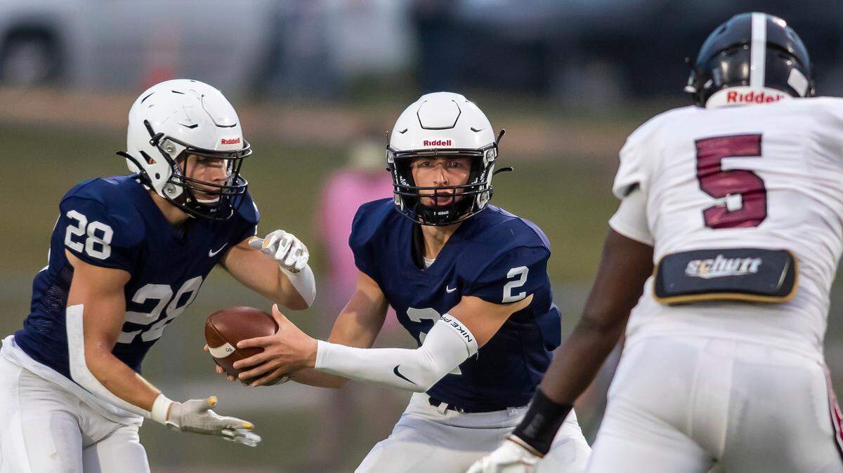 Mill Valley junior quarterback Hayden Jay hands the ball off to senior running back Reice Kennedy in Friday’s game against the Lawrence Chesty Lions on Friday September 24, 2021 in Shawnee, Kansas.