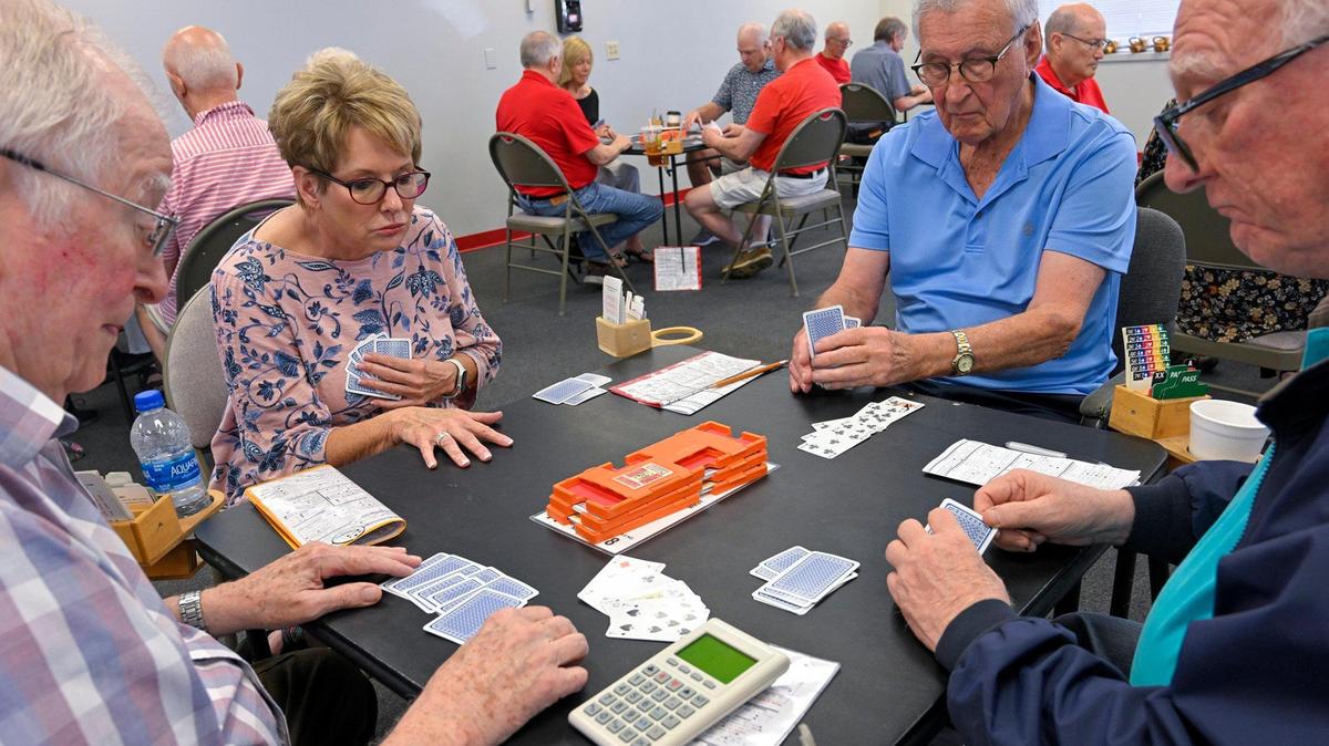 Beckie Stasi of Lenexa looked over the table as she played bridge with her regular crowd, Don Brooker of Fairway, clockwise from left, Paul Pressly of Olathe, and Don Stack of Kansas City, Kansas, at the Bridge Studio in Overland Park.