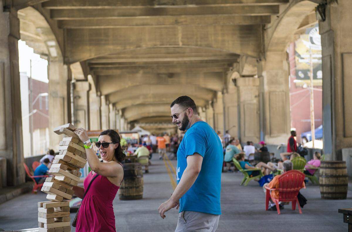 Megan Tobin reacts to the Jenga pile toppling as her husband, Ryan Tobin, both of Kansas City, watches on Saturday, June 20, 2015, during Boulevardia in the West Bottoms. Thousands of Kansas Citians turned out for the festival which was held over three days in 2015.