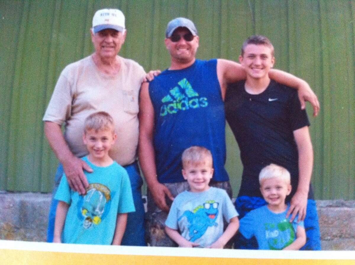 Travis Otto (center) poses with his father, Kenneth Otto, and his four sons.