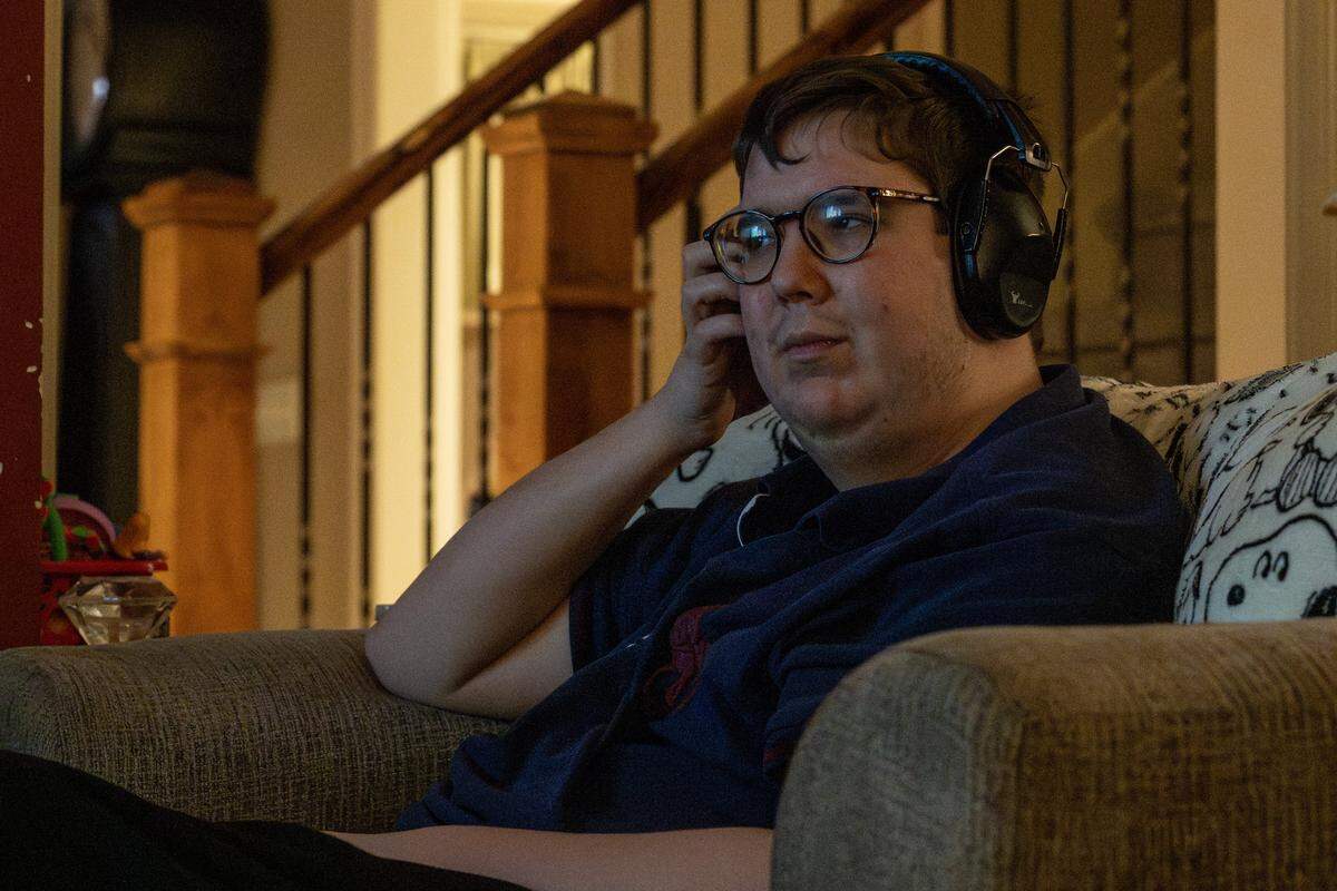 Harrison Long adjust his headphones while he watches Scooby-Doo in the living room of his home on Tuesday, Feb. 10, 2026, in Parkville.