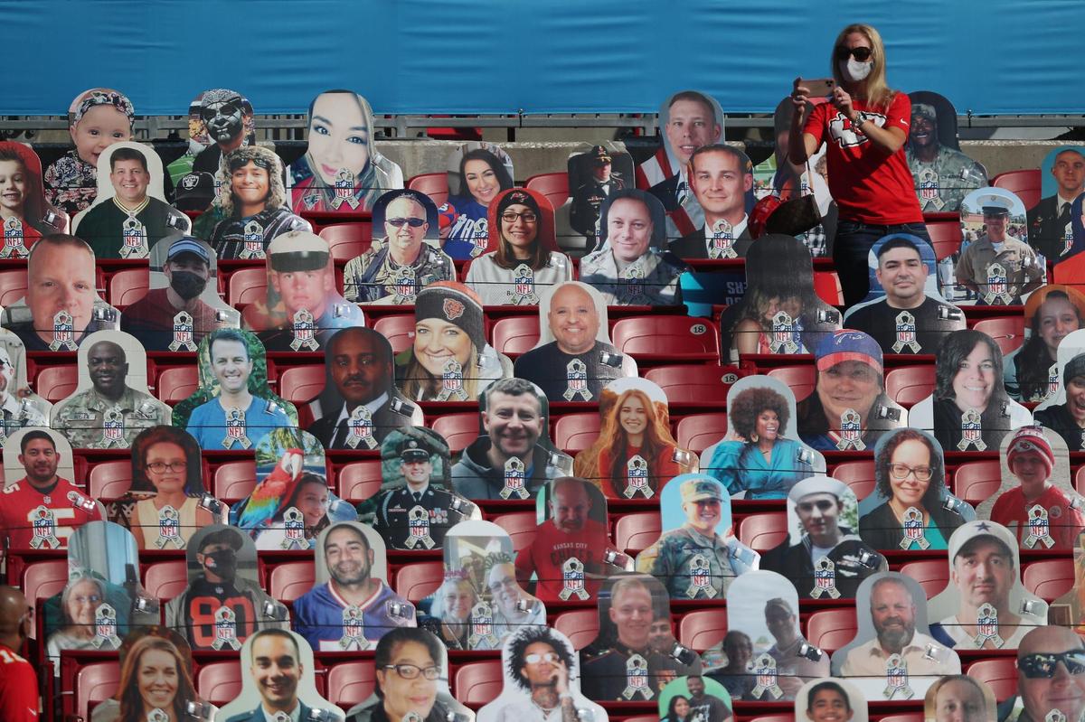 A real live fan takes photos of herself among the cutout fans in the stands Sunday, February 7, 2021, before the start of Super Bowl LV at Raymond James Stadium in Tampa, Florida.