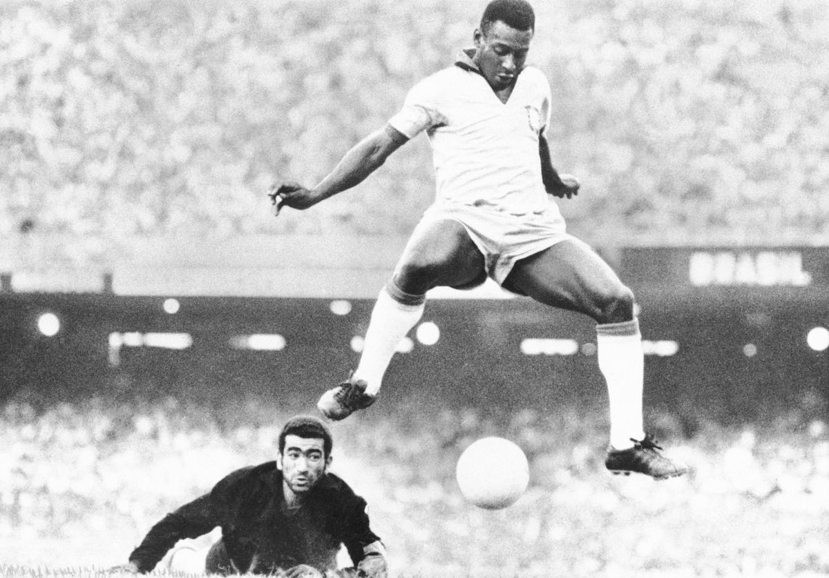 Brazil’s Pele leaps and scores past Venezuela goalkeeper Fabrizio Fasano during a 1969 match in Rio de Janeiro, Brazil.