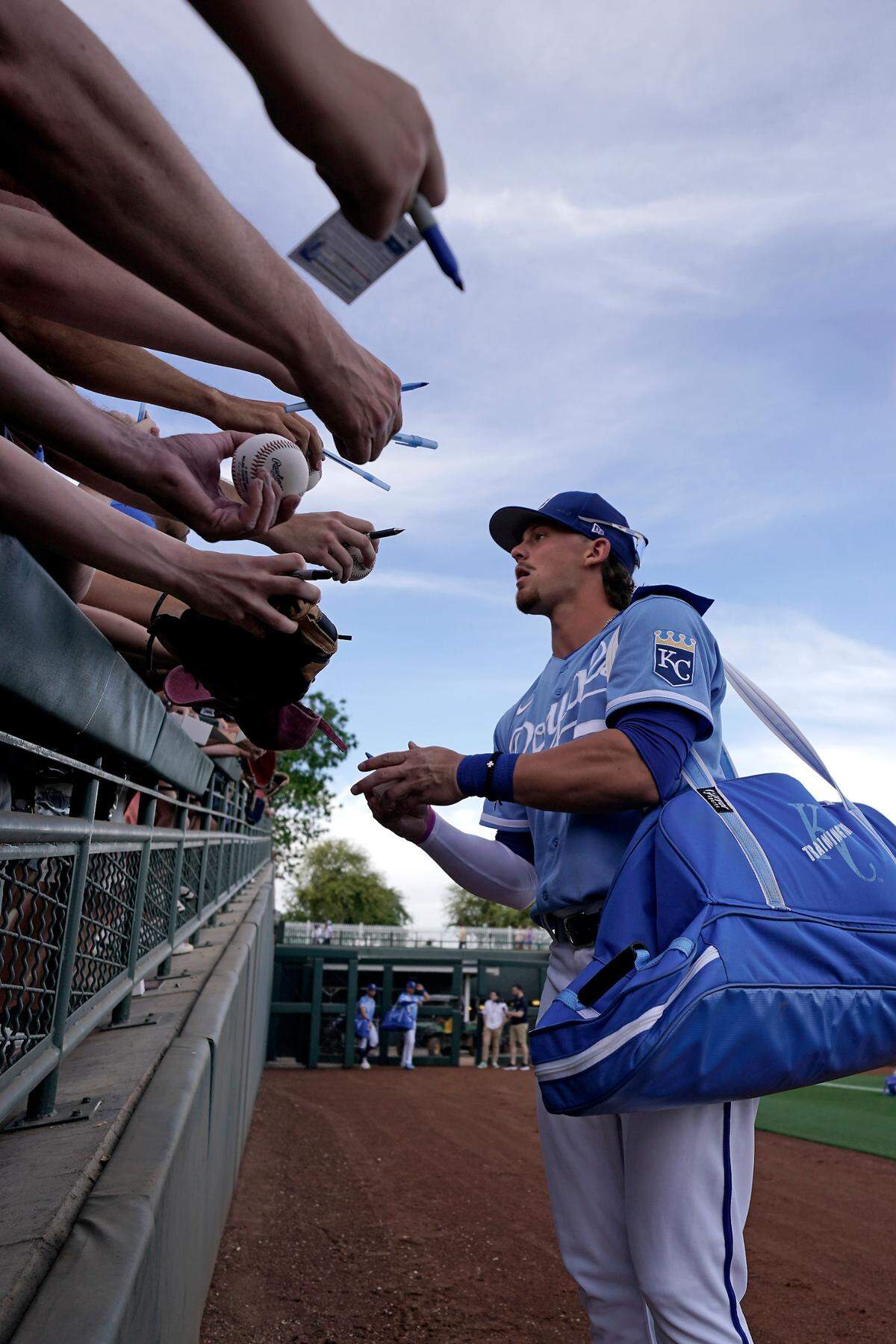 Kansas City Royals’ Bobby Witt Jr. signs autographs before a spring training baseball game against the Los Angeles Dodgers Saturday, March 26, 2022, in Surprise, Ariz.