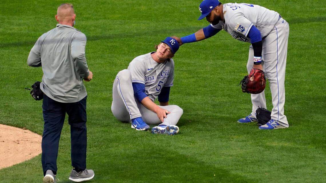 Kansas City Royals pitcher Brady Singer, center, holds his leg after a ball hit him during the second inning of the team’s baseball game against the Minnesota Twins, Friday, April 30, 2021, in Minneapolis. Singer left the game. (AP Photo/Jim Mone)