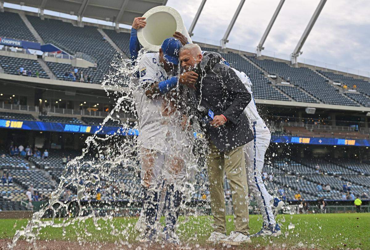Kansas City Royals Salvador Perez (13) and broadcaster Joel Goldberg get doused with ice water after beating the Colorado Rockies at Kauffman Stadium on Apr 24, 2025 in Kansas City, Missouri, USA.