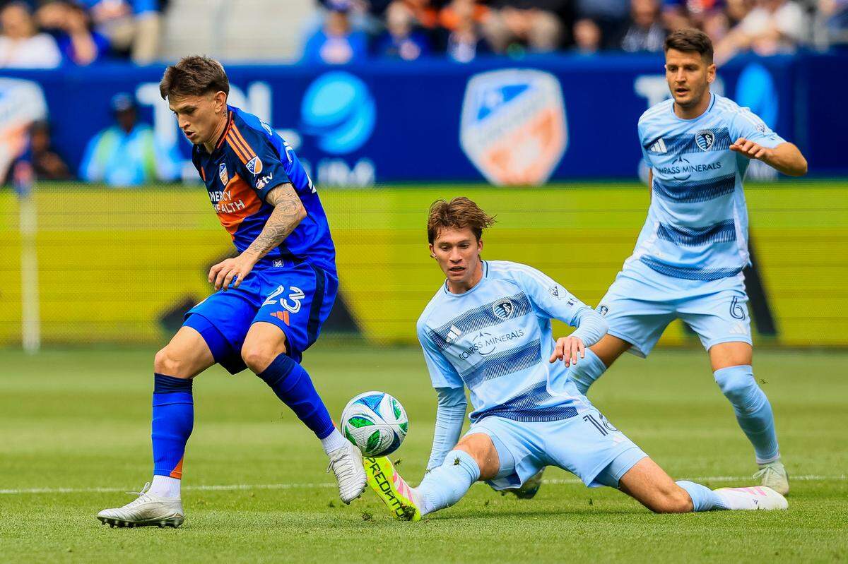 Sporting Kansas City midfielder Jacob Bartlett (16) battles for the ball against FC Cincinnati midfielder Luca Orellano (23) in the first half at TQL Stadium on April 26, 2025.
