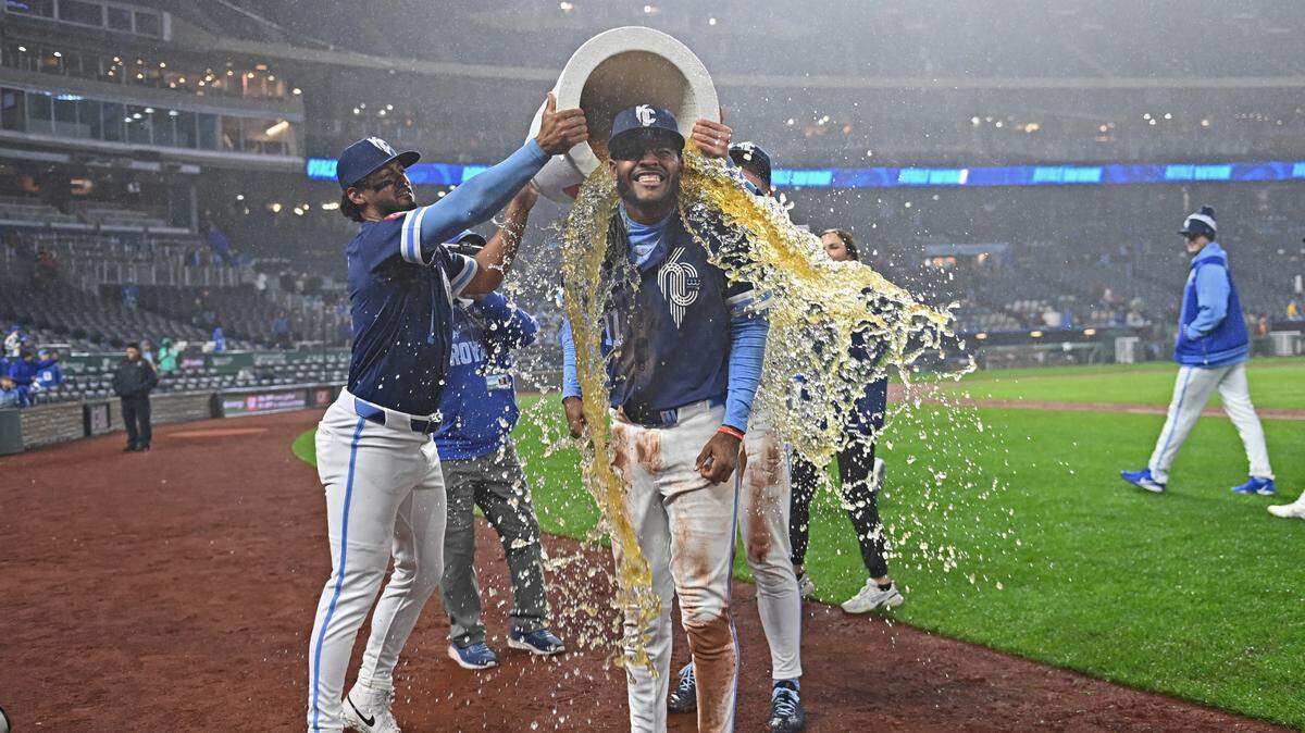 Kansas City Royals third baseman Maikel Garcia (center) gets doused by teammates MJ Melendez (left) and Bobby Witt Jr. (right) after beating the Baltimore Orioles at Kauffman Stadium on April 4, 2025 in Kansas City.
