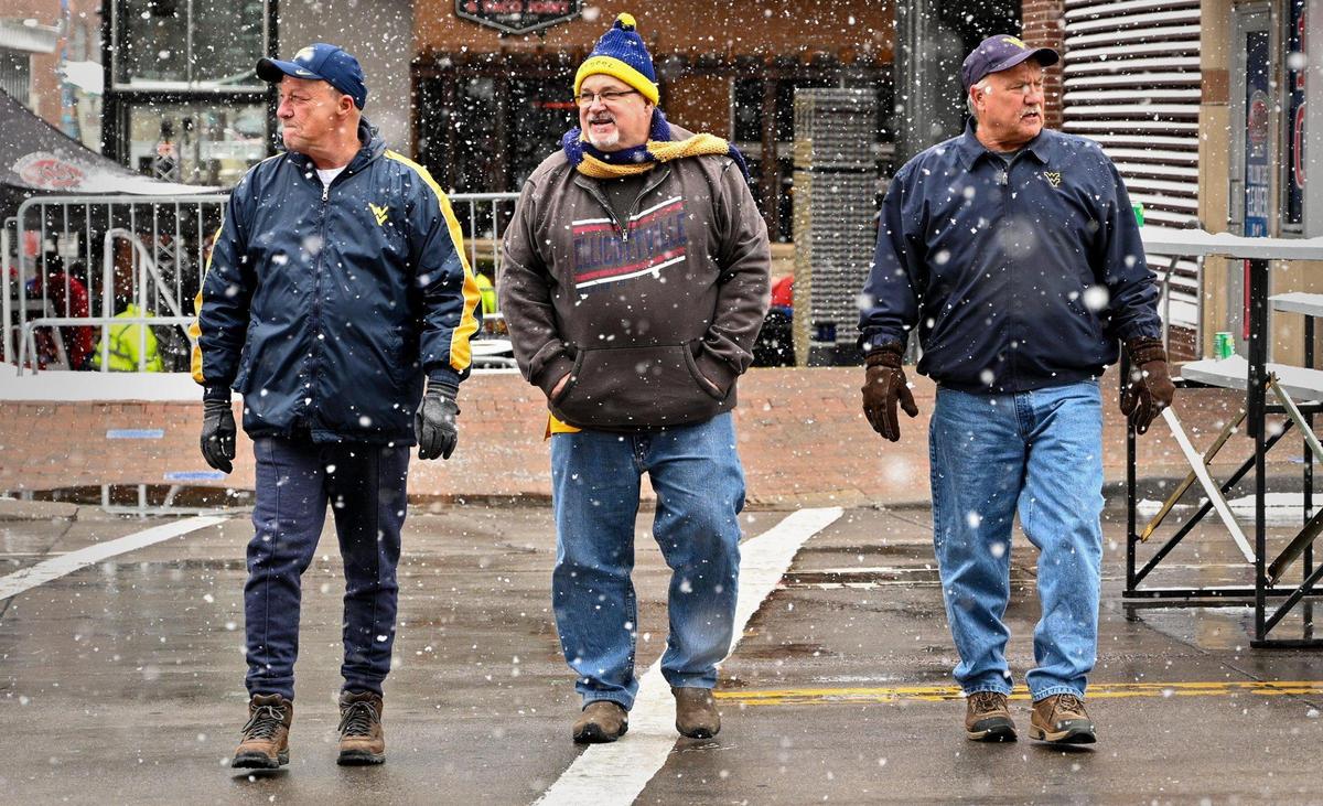 Brothers Ed Crist, of South Charleston, W.Va., from left, Andy Crist of Alexander City, Ala., and Bruce Gresham of Charleston, W.Va., head to the the T-Mobile Center for the Kansas and West Virginia game of the Big 12 tournament Thursday, Mar. 10, 2022.