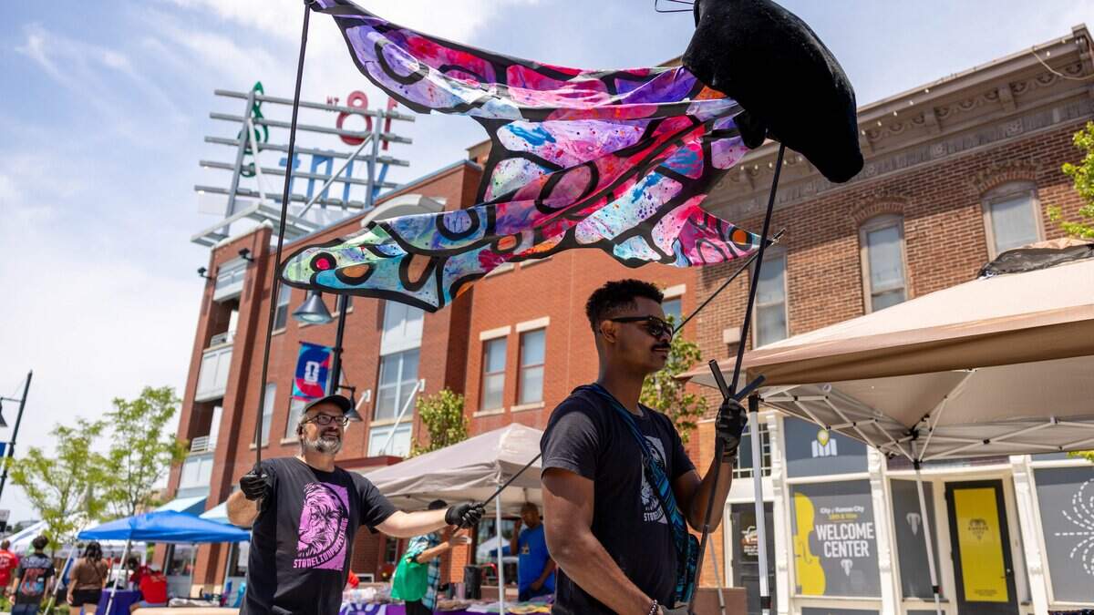 Stone Lion Puppet Theater employees Jean-Jacques Corbier, front, and Justine Howe walk through the street with a butterfly puppet during JuneteenthKC 15th Annual Heritage Festival at E 18th Street on Saturday, June 20, 2026.