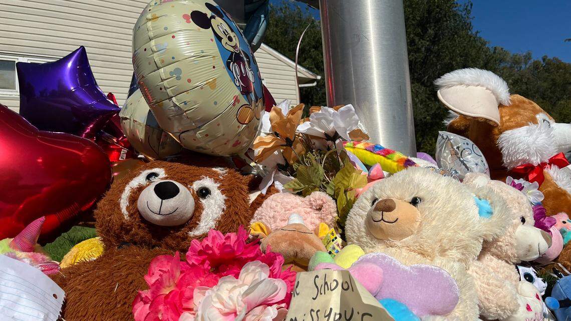 Flowers, notes, toys and balloons placed at a light post at the intersection where 3rd-grader Hazen Workman-Duffy was killed while biking to school in south Kansas City Tuesday.
