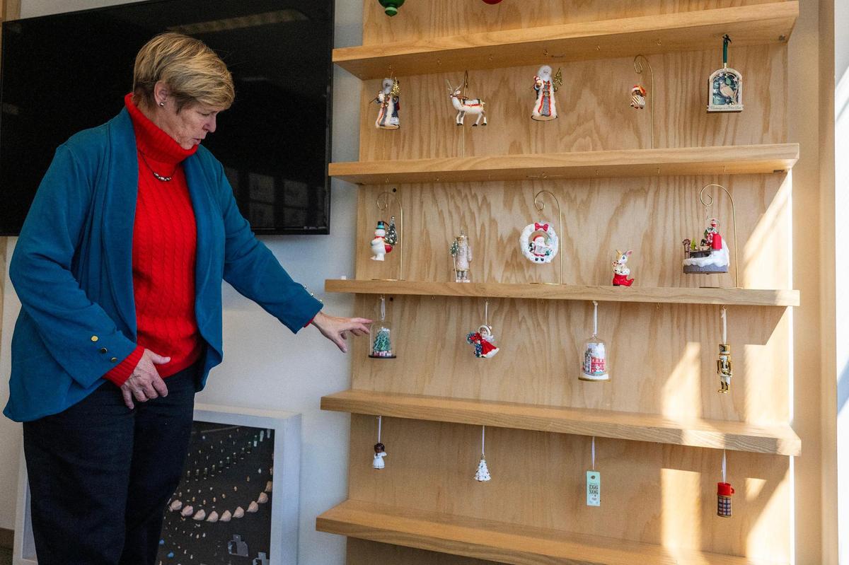 Artist Sharon Visker explains the designs and categories of ornaments displayed on a wall at Hallmark headquarters.