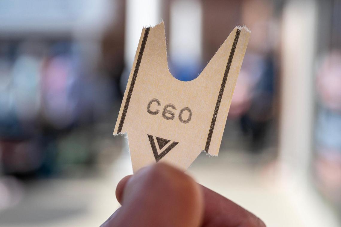 David Arciga holds his ticket while waiting in line outside the Kansas City DMV on Wednesday, May 7, 2025, in Kansas City. Arciga, who was applying for a Real ID, said he had already been waiting for an hour and a half and his number still hadn’t been called.