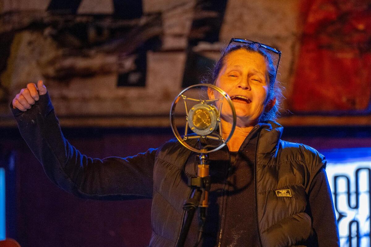 “We speak out, we vote No, we sing and we hum,” C. Woods sang during an a cappella performance on Monday at the Rural Grit Happy Hour. “Because the vote is on for the stadium.”