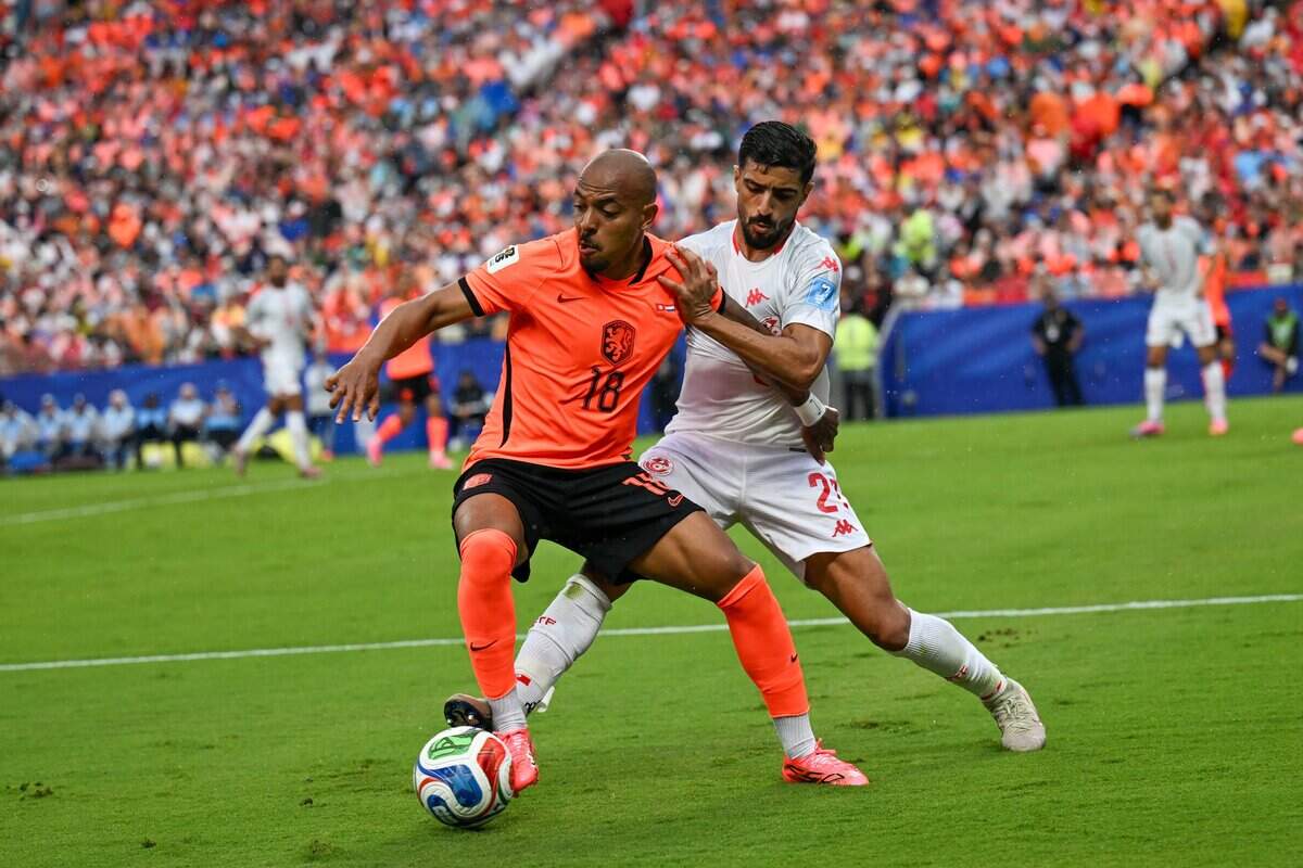 Netherlands midfielder Donyell Malen (18) and Tunisia defender Ali Abdi (2) fight for the ball in the first half of the Netherlands vs. Tunisia FIFA World Cup group-stage soccer match at Kansas City (Arrowhead) Stadium in Kansas City on Thursday, June 25, 2026.