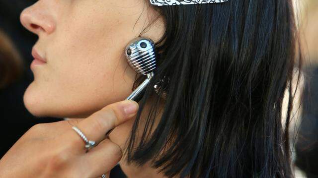 A woman using a facial roller.