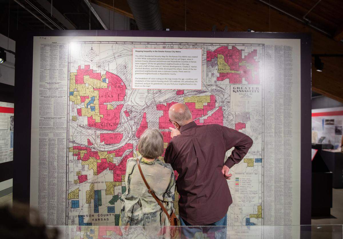 Visitors at the Johnson County Museum check out the museum’s exhibit on redlining.