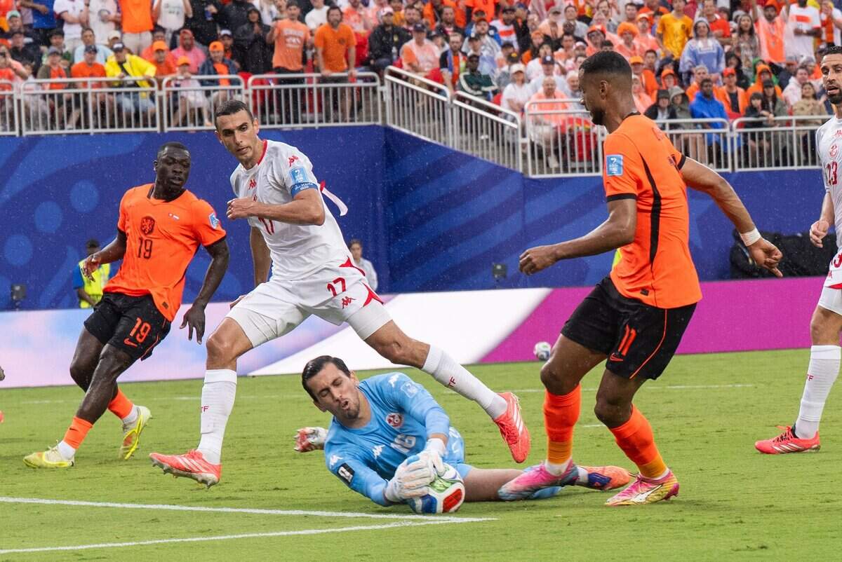 Tunisia goalkeeper Aymen Dahmen (16) makes sliding save in a FIFA World Cup group-stage soccer match at Kansas City (Arrowhead) Stadium in Kansas City on Thursday, June 25, 2026.