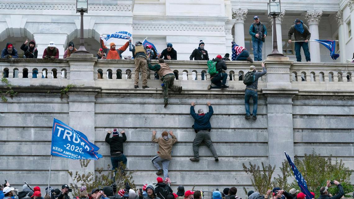 Supporters of President Donald Trump climb the west wall of the the U.S. Capitol on Wednesday, Jan. 6, 2021, in Washington. (AP Photo/Jose Luis Magana)