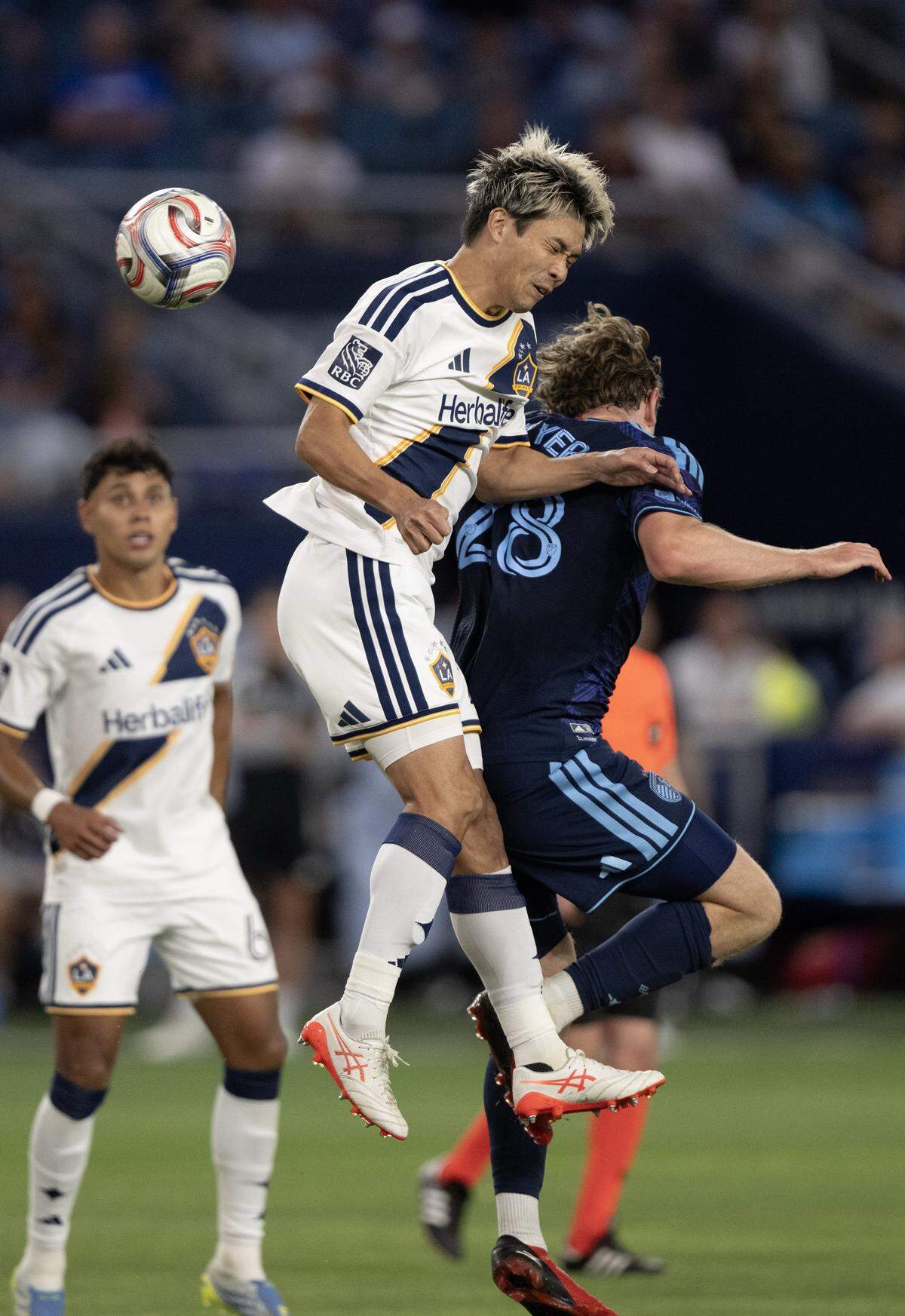 LA Galaxy defender Miki Yamane (2) and Sporting Kansas City defender Wyatt Meyer (28) head for the ball during the second half at Sporting Park on Wednesday, May 13, 2026, 2026, in Kansas City, Kansas. Sporting KC defeated the LA Galaxy, 3-1.