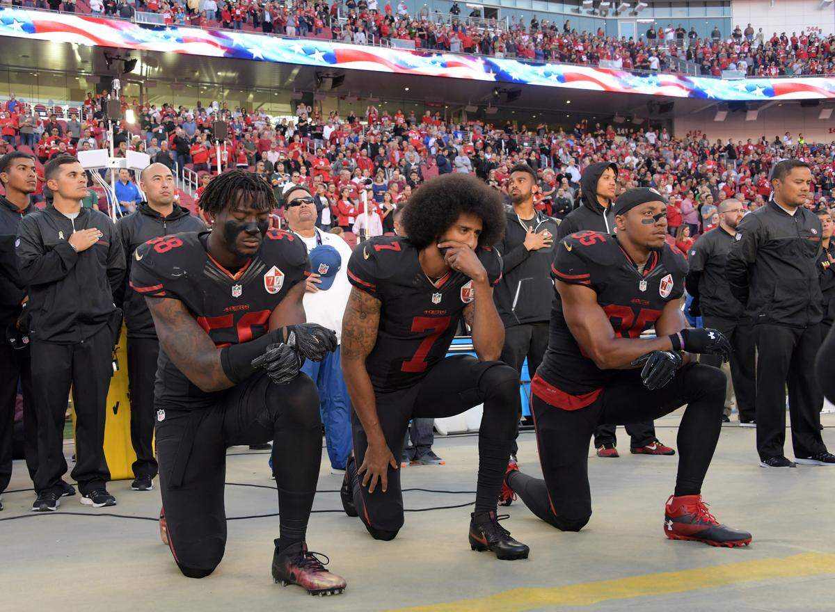 Oct 6, 2016; Santa Clara, CA, USA; San Francisco 49ers outside linebacker Eli Harold (58), quarterback Colin Kaepernick (7) and free safety Eric Reid (35) kneel in protest during the playing of the national anthem before a NFL game against the Arizona Cardinals at Levi's Stadium. Mandatory Credit: Kirby Lee-USA TODAY Sports