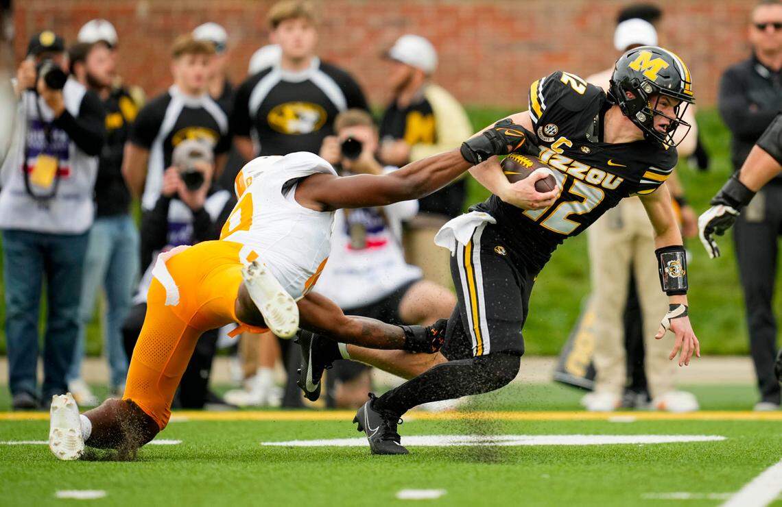 Missouri Tigers quarterback Brady Cook pulls Tennessee Volunteers defensive lineman Elijah Simmons for a couple of extra yards during Saturday’s game at Faurot Field.