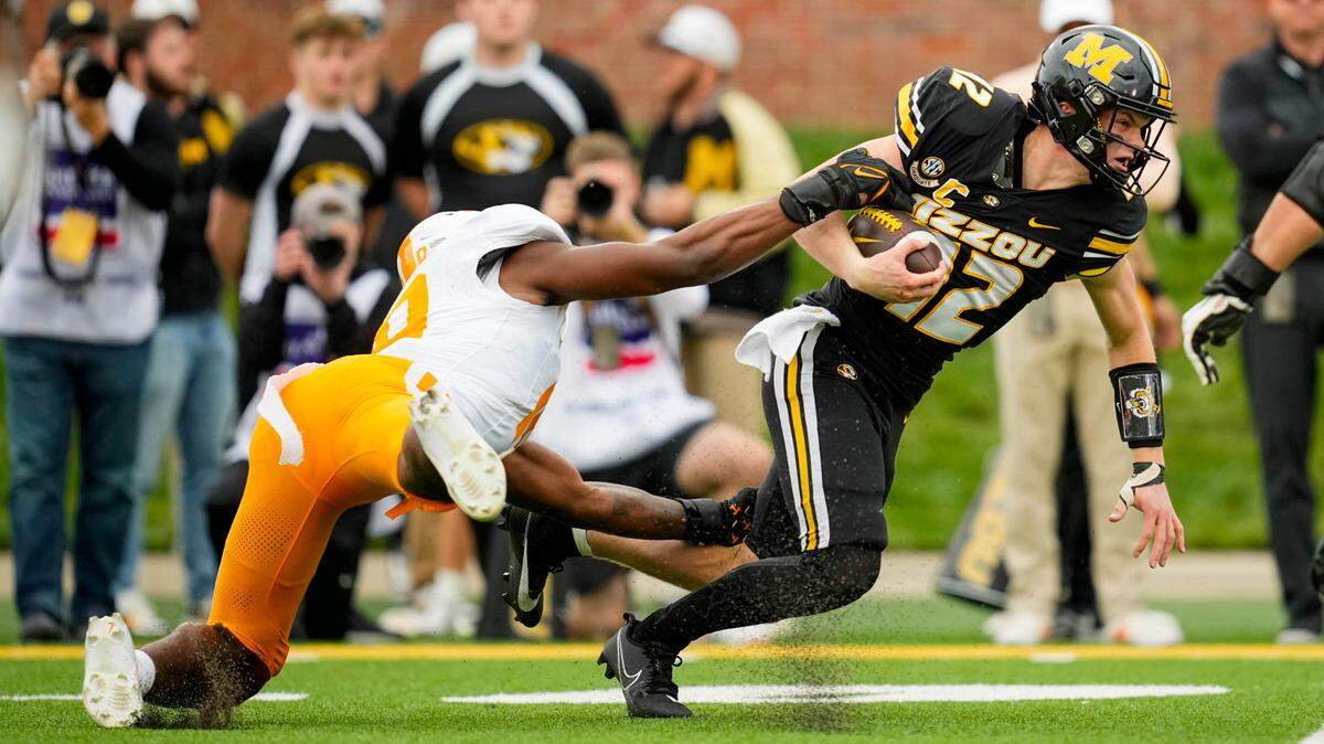 Missouri Tigers quarterback Brady Cook pulls Tennessee Volunteers defensive lineman Elijah Simmons for a couple of extra yards during Saturday’s game at Faurot Field.