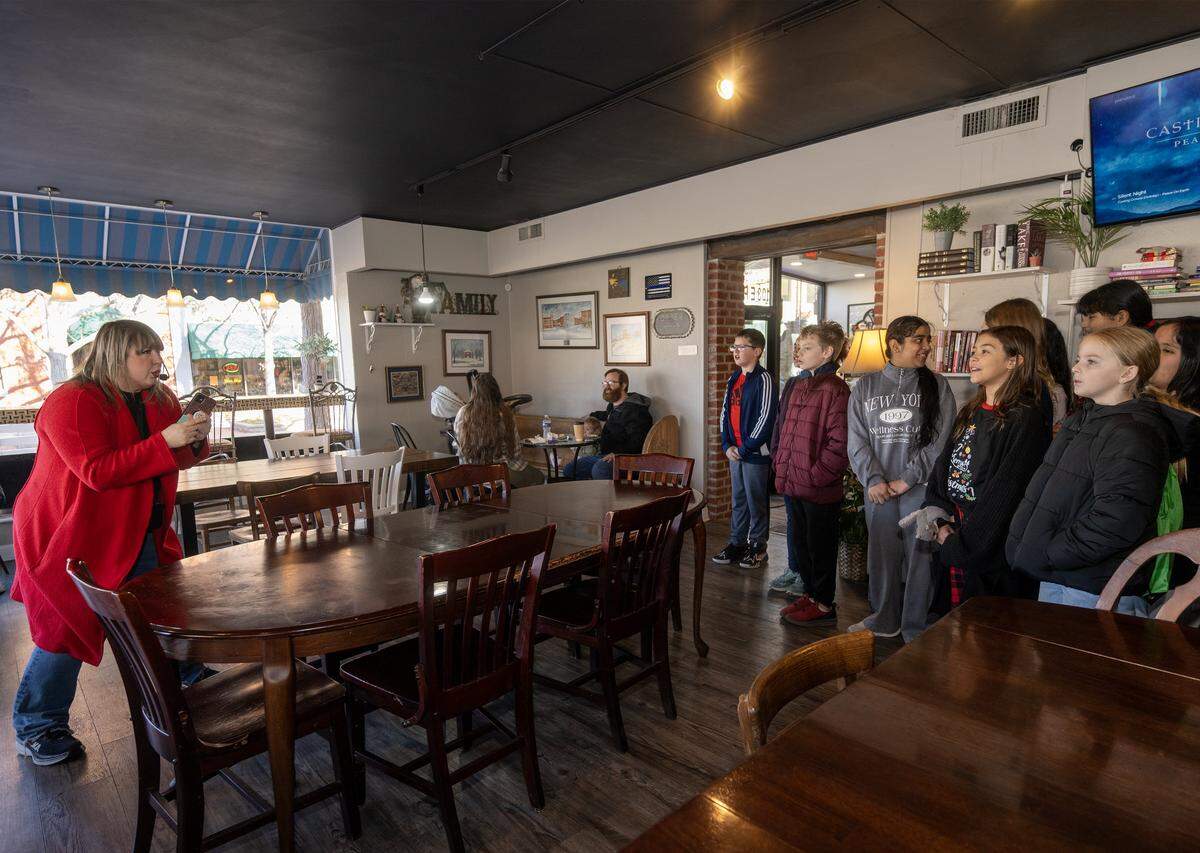 Music teacher Rachel Marlow directs special chorus students from Central Elementary School in sining Christmas carols at Park Street Pastry on Wednesday, Dec. 17, 2025, in Olathe.