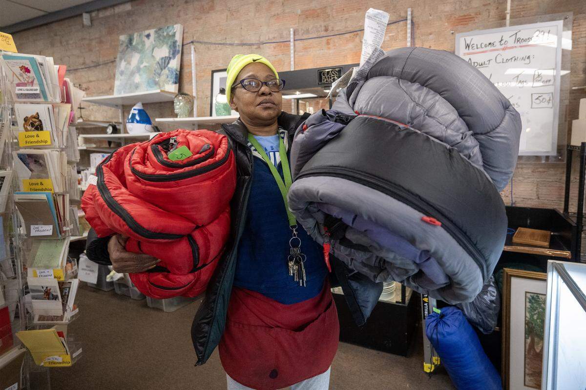 Adrienne Williams of Kansas City carries a couple sleeping bags out of Troost39, a thrift store where she purchased them on Thursday, Jan. 22 2026, in Kansas City. Williams will give the items to some unhoused individuals.