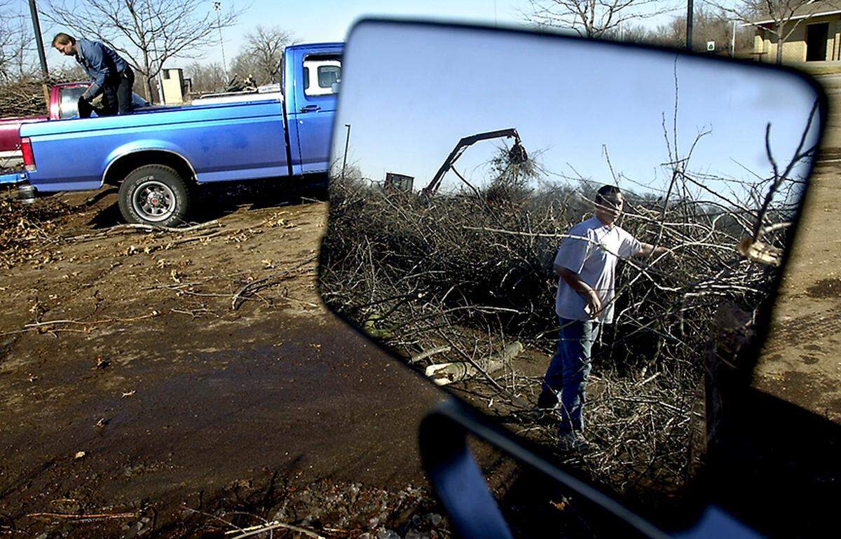Once the thick ice melted from trees after the ice storm, it was time to clear debris. Ronnie Fellers of Blue Springs unloaded tree limbs from his truck in 2002.